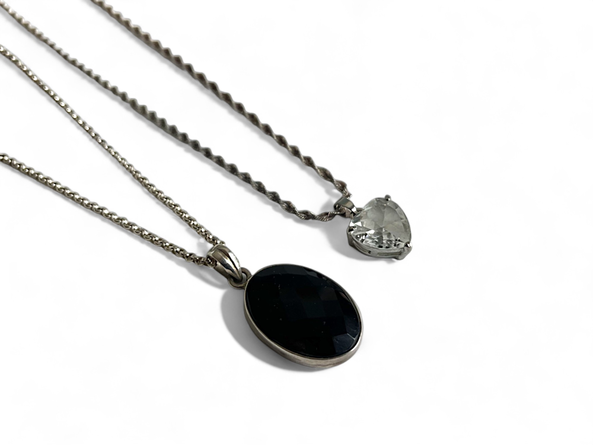 A silver and facet cut black onyx cabochon pendant necklace. together with a gold plated heart shape