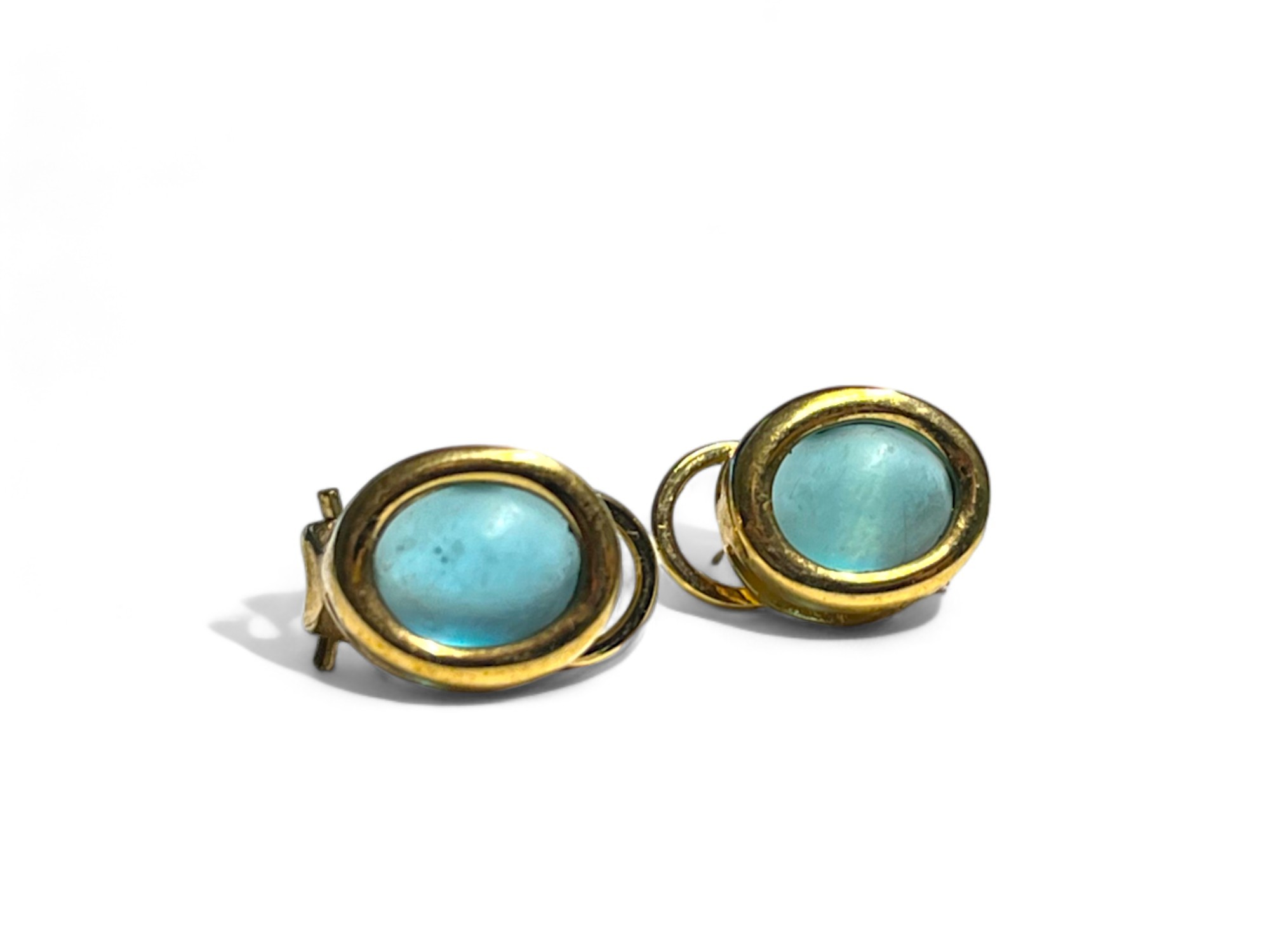 A pair of yellow metal & blue cabochon stone set earrings. 