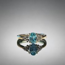 A ladies 9ct Gold ring. Set with central blue stone, possibly Topaz? bordered with six diamonds. Si
