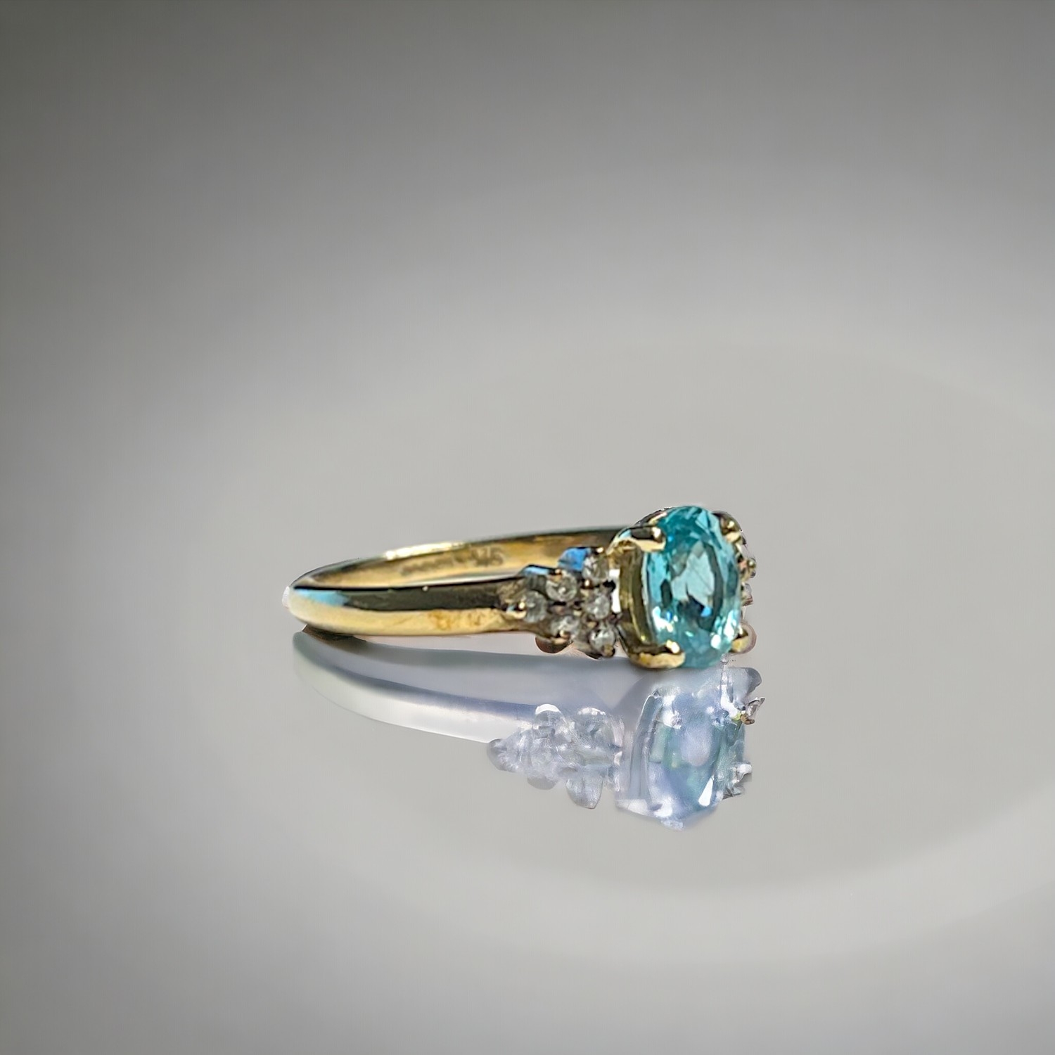 A ladies 9ct Gold ring. Set with central blue stone, possibly Topaz? bordered with six diamonds.  Si - Image 2 of 2