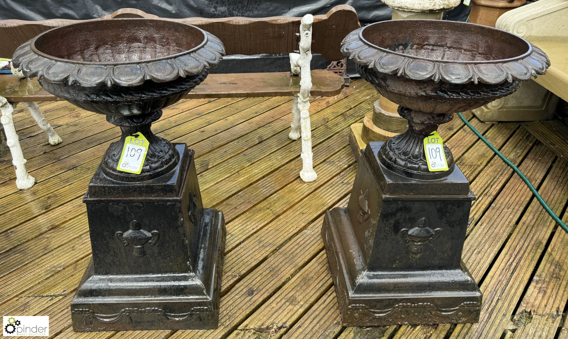 A pair cast iron Garden Urns, with egg and dart decoration on cast iron plinths, with fruit and swag
