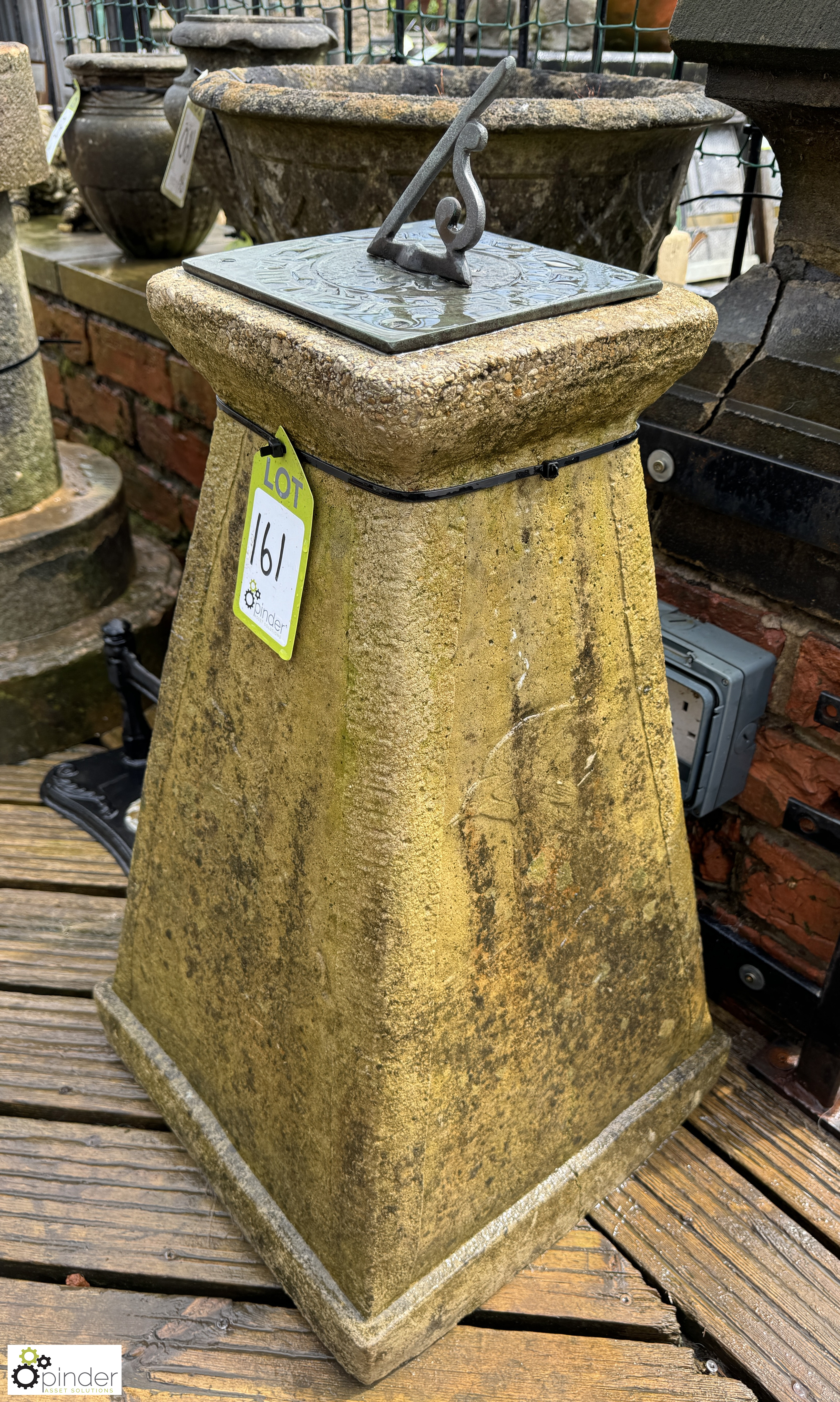 A reconstituted stone obelisk style Sundial Plinth, with bronze sundial plate with Roman numerals,