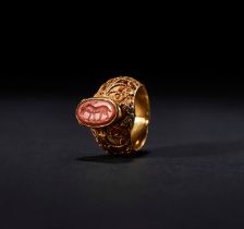 A CARVED CARNELIAN INTAGLIO "BULL" RING SET ON GOLD