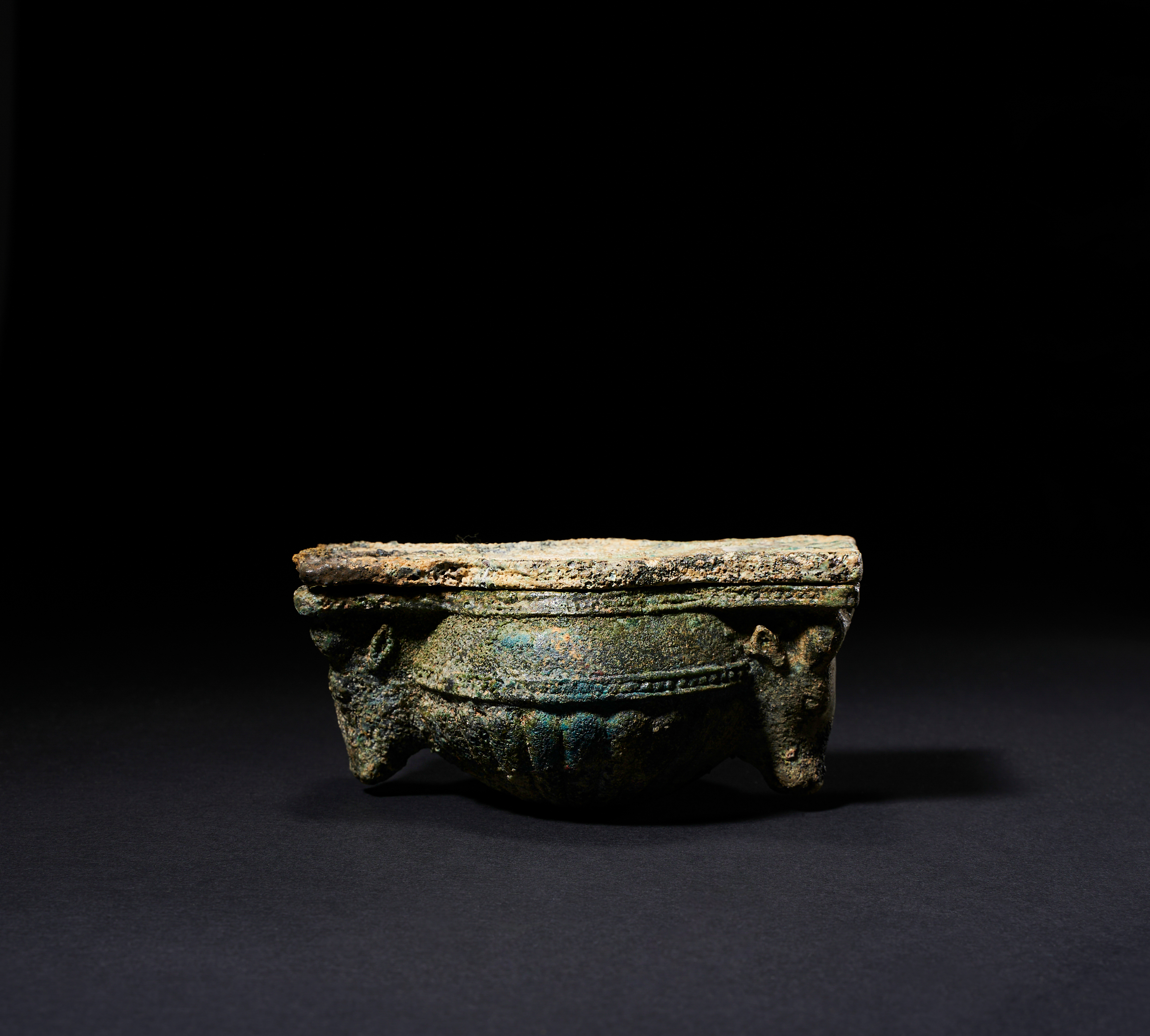 A HIGHLY RARE PASTE GLASS ZIWIYE BULL HEAD LIDDED BOX, CIRCA 7TH CENTURY B.C.