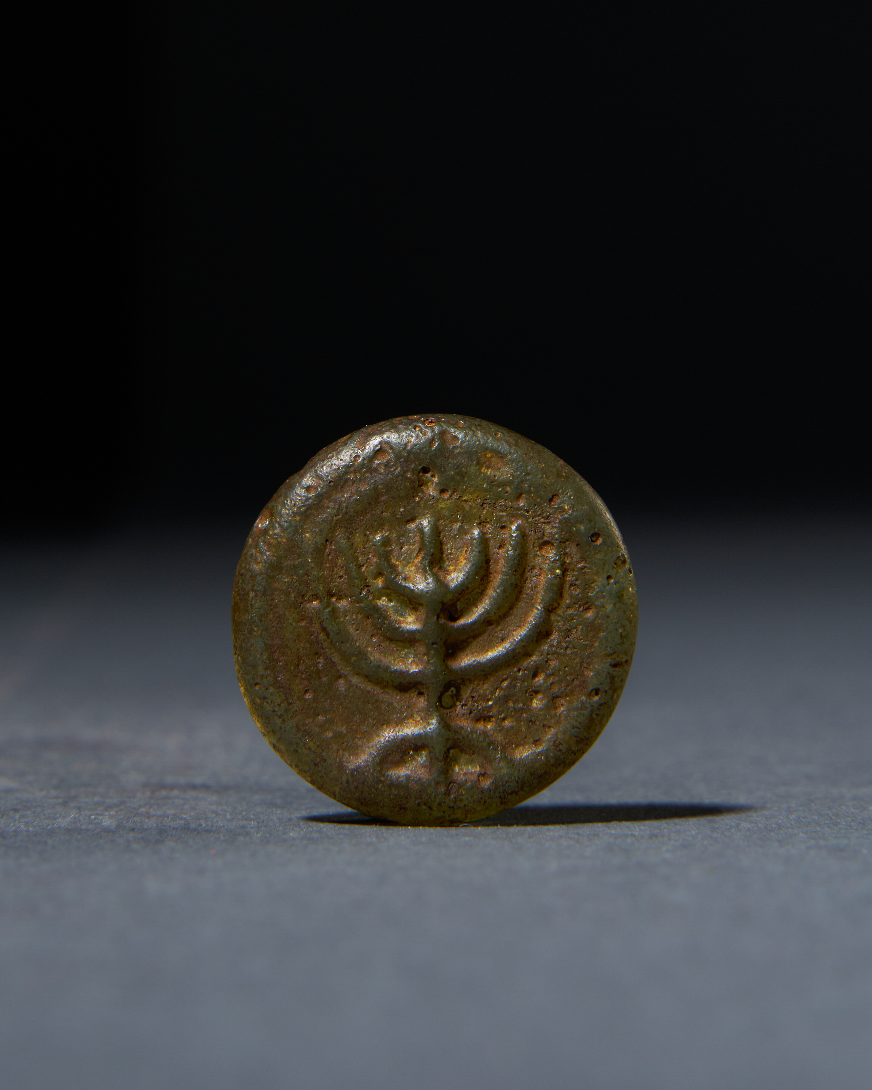 A ROMAN GLASS MENORAH AMULET, CIRCA 1ST CENTURY A.D.