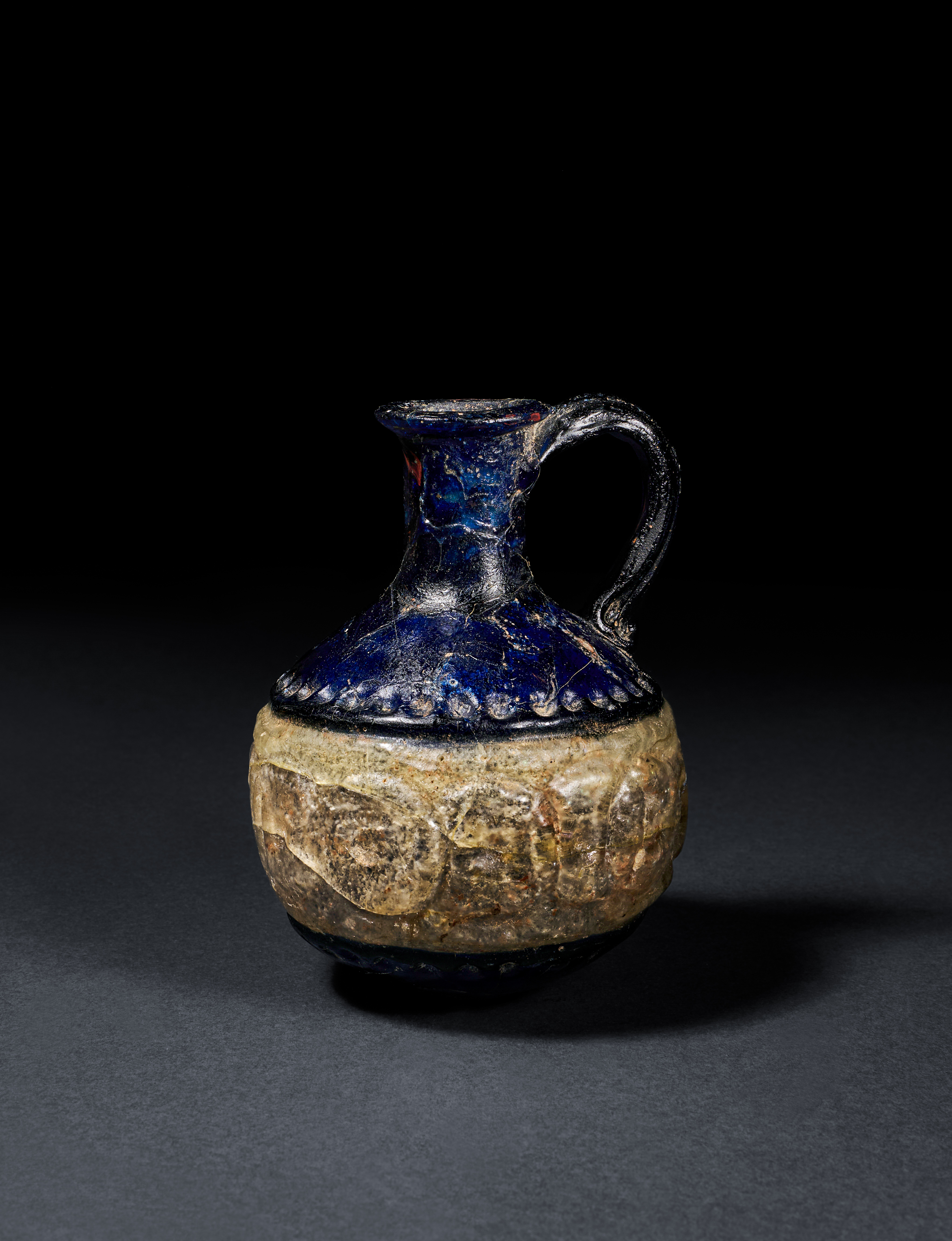 AN EARLY DOUBLE LAYERED ISLAMIC GLASS EWER, PROBABLY ABBASID, CIRCA 9TH CENTURY