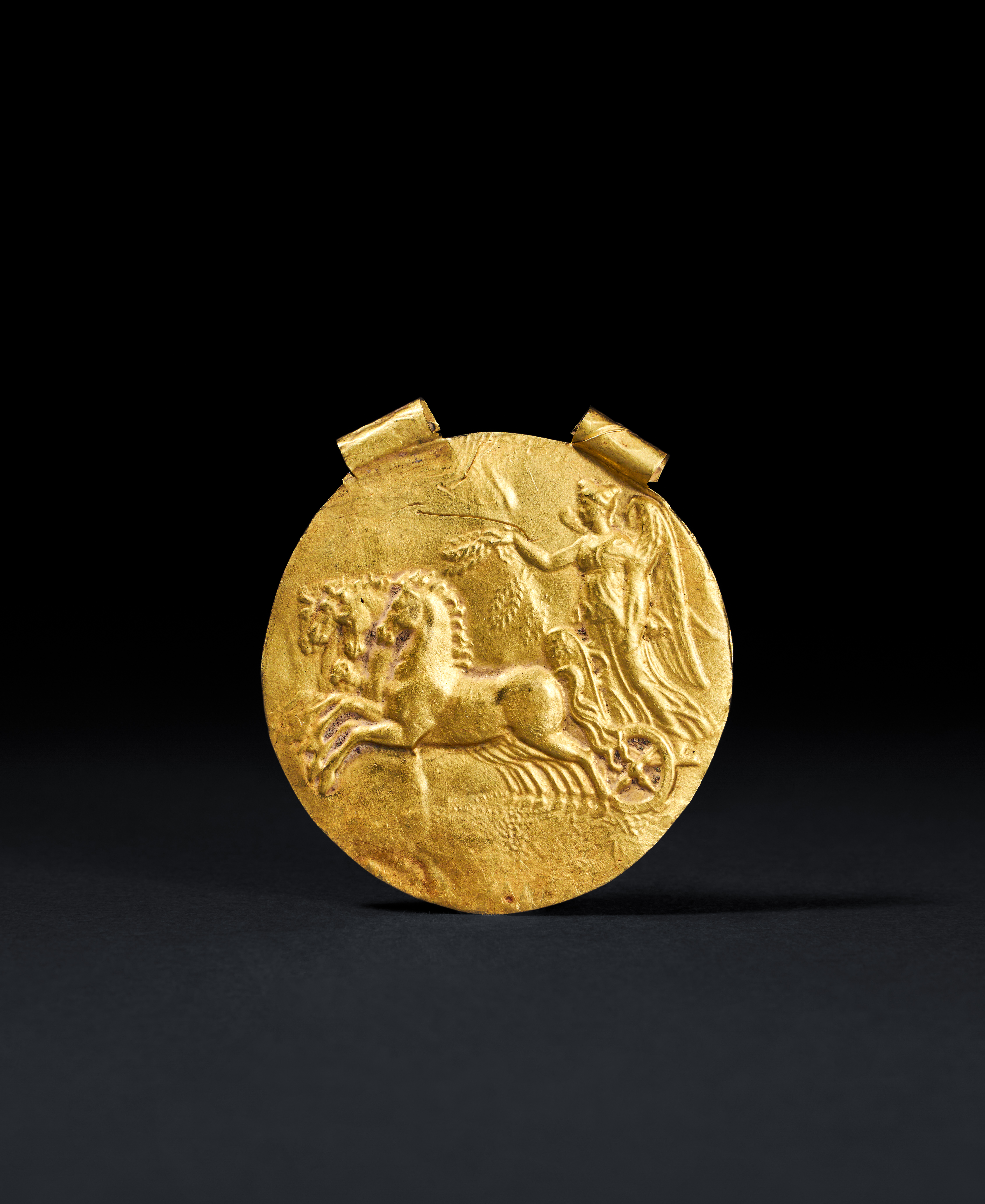A HELLENISTIC GOLD APPLIQUE OF ATHENA CHARIOT RACING, HELLENISTIC PERIOD, CIRCA 3RD CENTURY B.C.