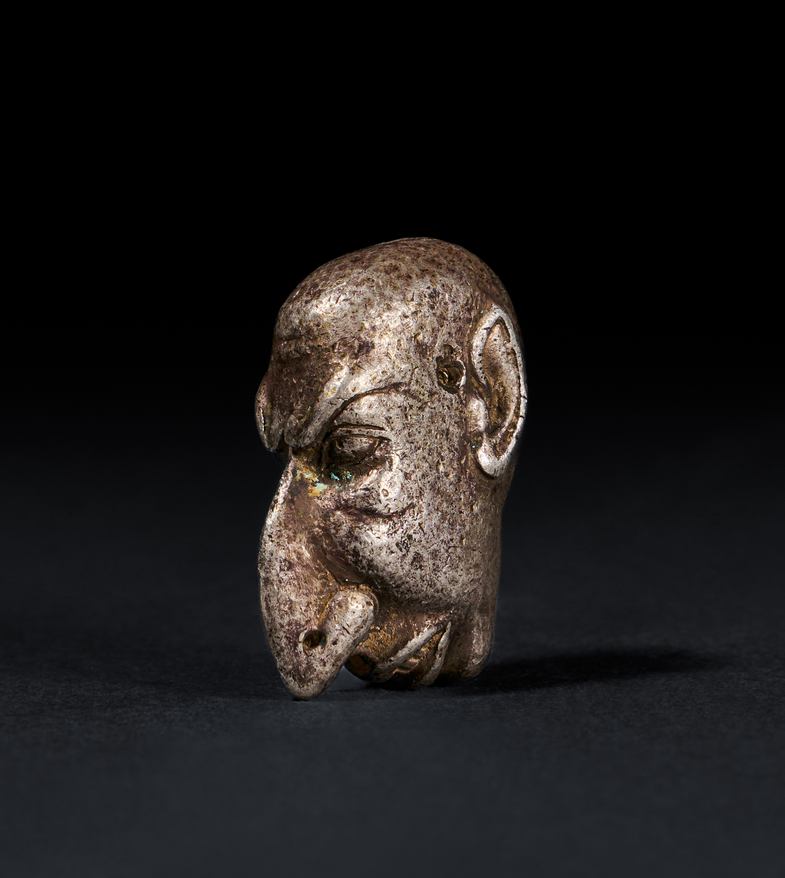 A ROMAN SOLID SILVER AMULET OF A "GROTESK" FACE, CIRCA 1ST-2ND CENTURY A.D.