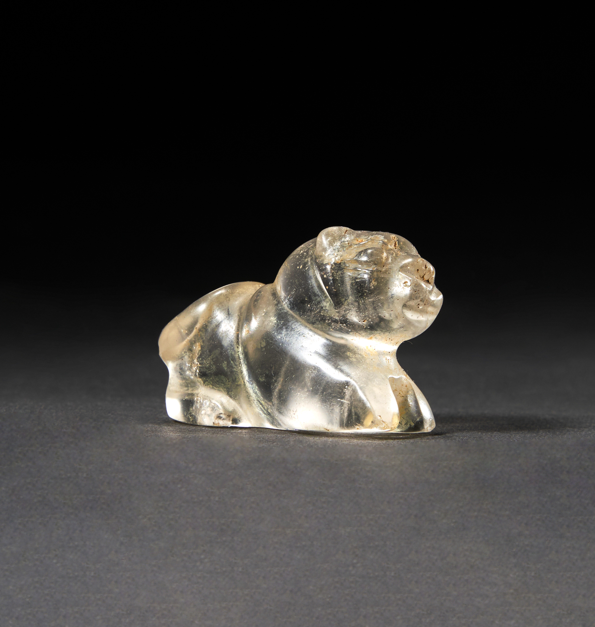 A GREEK ROCK CRYSTAL AMULET OF A RECUMBENT FELINE, CIRCA 5TH CENTURY A.D. OR LATER