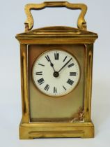 Brass Carriage clock with glass panels and door. Enamel dial. Working order. (small amount of damage