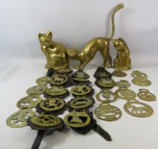 3 Large brass cat figures and a selection of horse brasses.