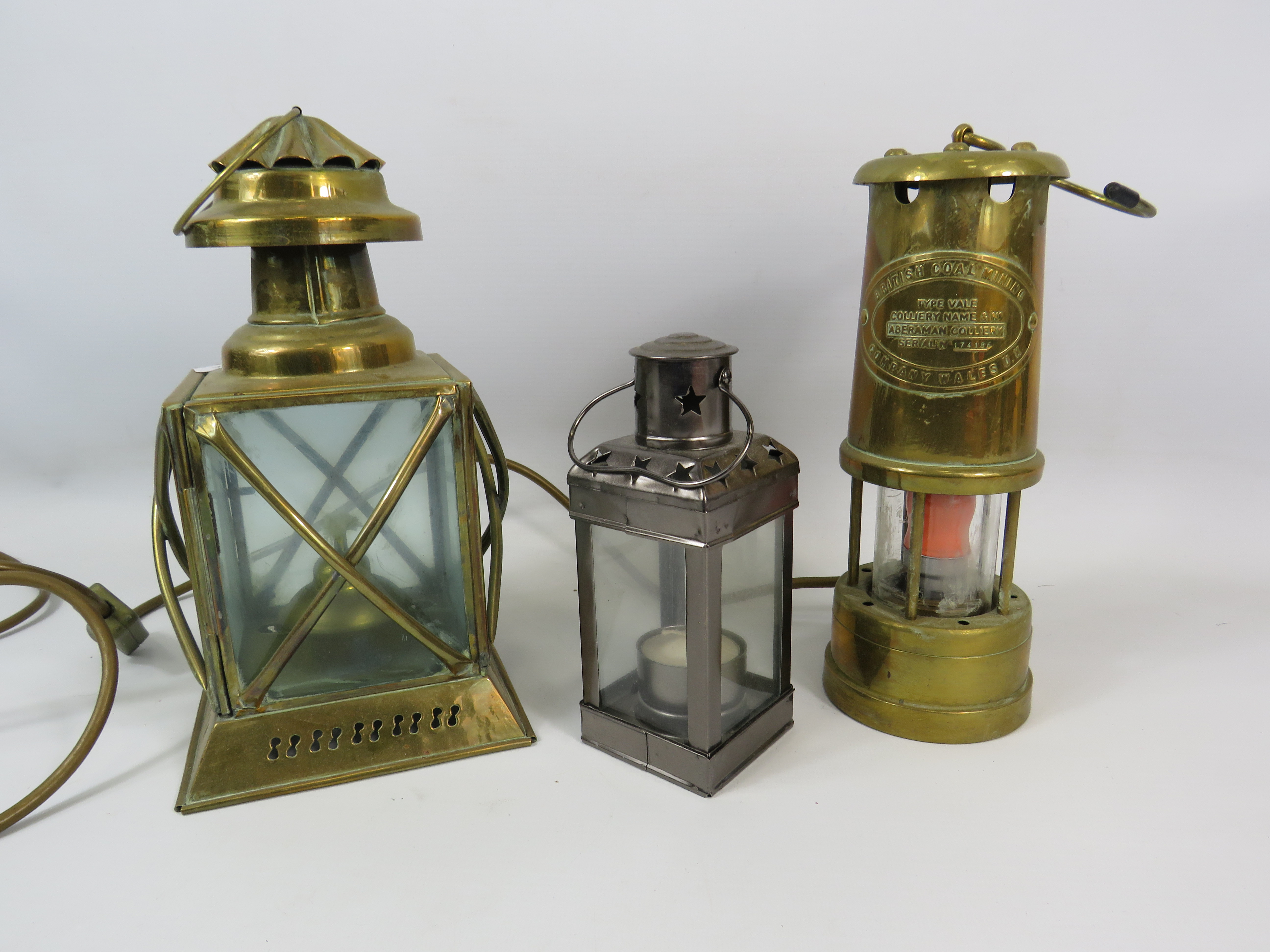 British Coal Mining Type Vale converted to electric lamp, a brass storm lantern and a tea light