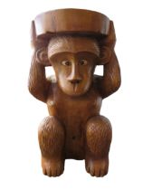 Carved wooden occasional table or seat in the form of a monkey, 52cm tall.