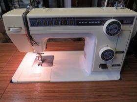 New Home Electric Sewing machine with handy drop leaf work table and oak chair. Working condition u