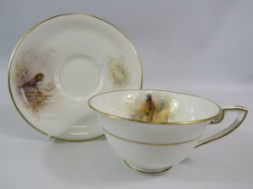 1949 Royal Worcester J Stinton cup and saucer, the cup painted with a pheasent and the saucer a