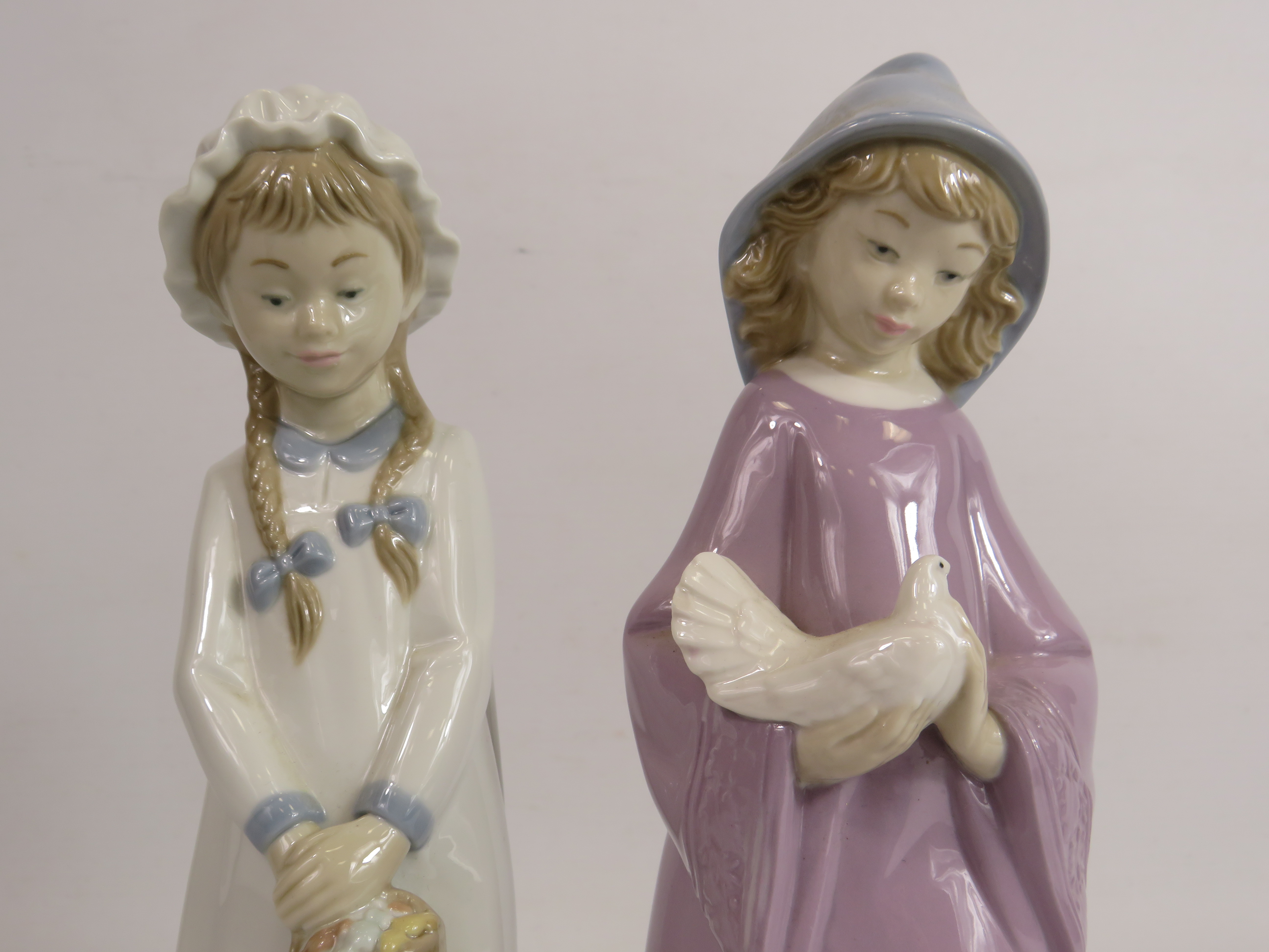 2 Nao figurines of girls, one holding a dove and one holding a basket. The tallest stands 27cm. - Image 2 of 3