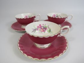 3 Susie Cooper pink cabinet cups and saucers with floral decoration to the bowl.