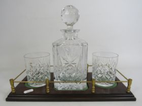 Whiskey decanter set on a wooden tray with brass gallery surround.