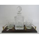 Whiskey decanter set on a wooden tray with brass gallery surround.