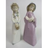 2 Nao figurines of girls, one holding a dove and one holding a basket. The tallest stands 27cm.