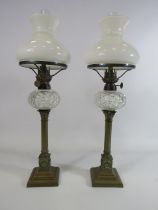 Two vintage brass oil lamps with column bases and crystal glass reserve, approx 21" tall.