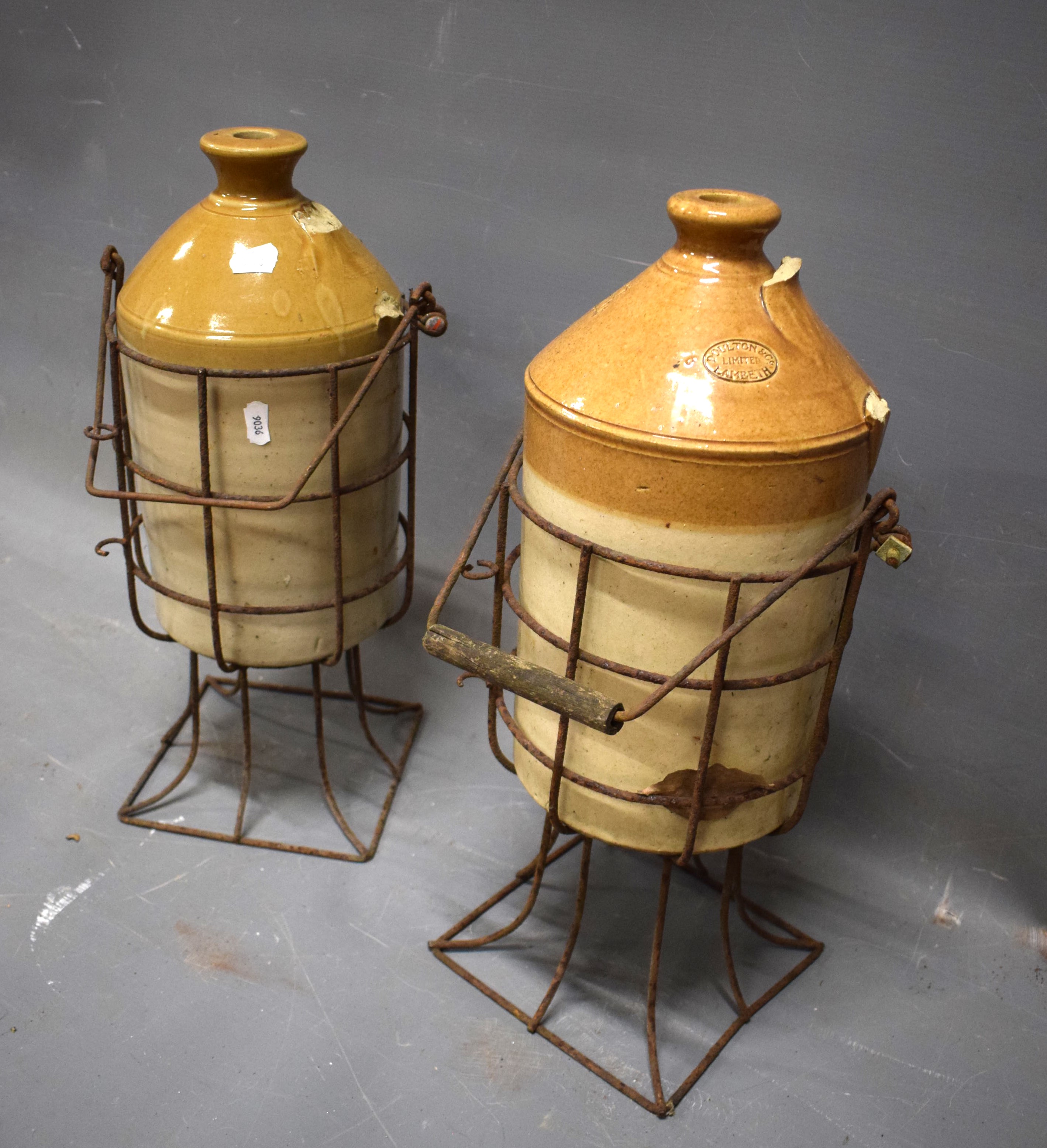 Two Stoneware flagon jars cradled inside a wire crate. Both jar handles missing. Each approx 19 inch - Image 2 of 2