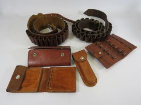 Two leather ammo belts and a selection of round holsters.