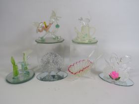 Five art glass figurines on mirrored bases and a lattice glass wheel barrow,