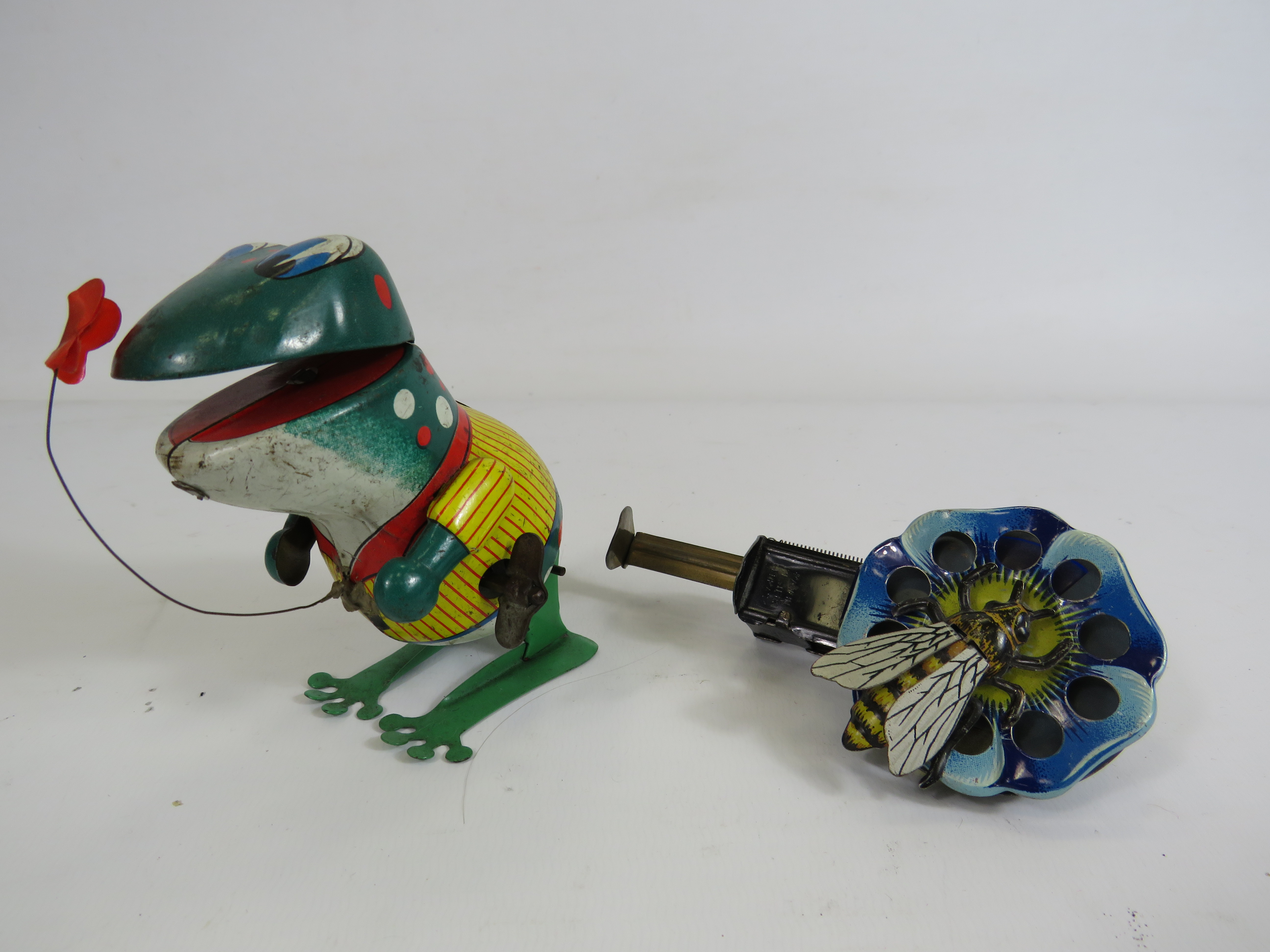 West German mechanical lever tin toy bee on a flower & a Japanese wind up tin frog.