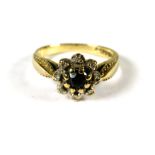 9ct Yellow Gold ring set with a small Circular Central Sapphire with Diamond surround in a flower pa