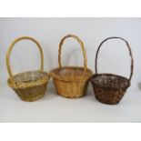 3 Wicker baskets with handles, the tallest measures 15.5" tall with a diameter of 12".