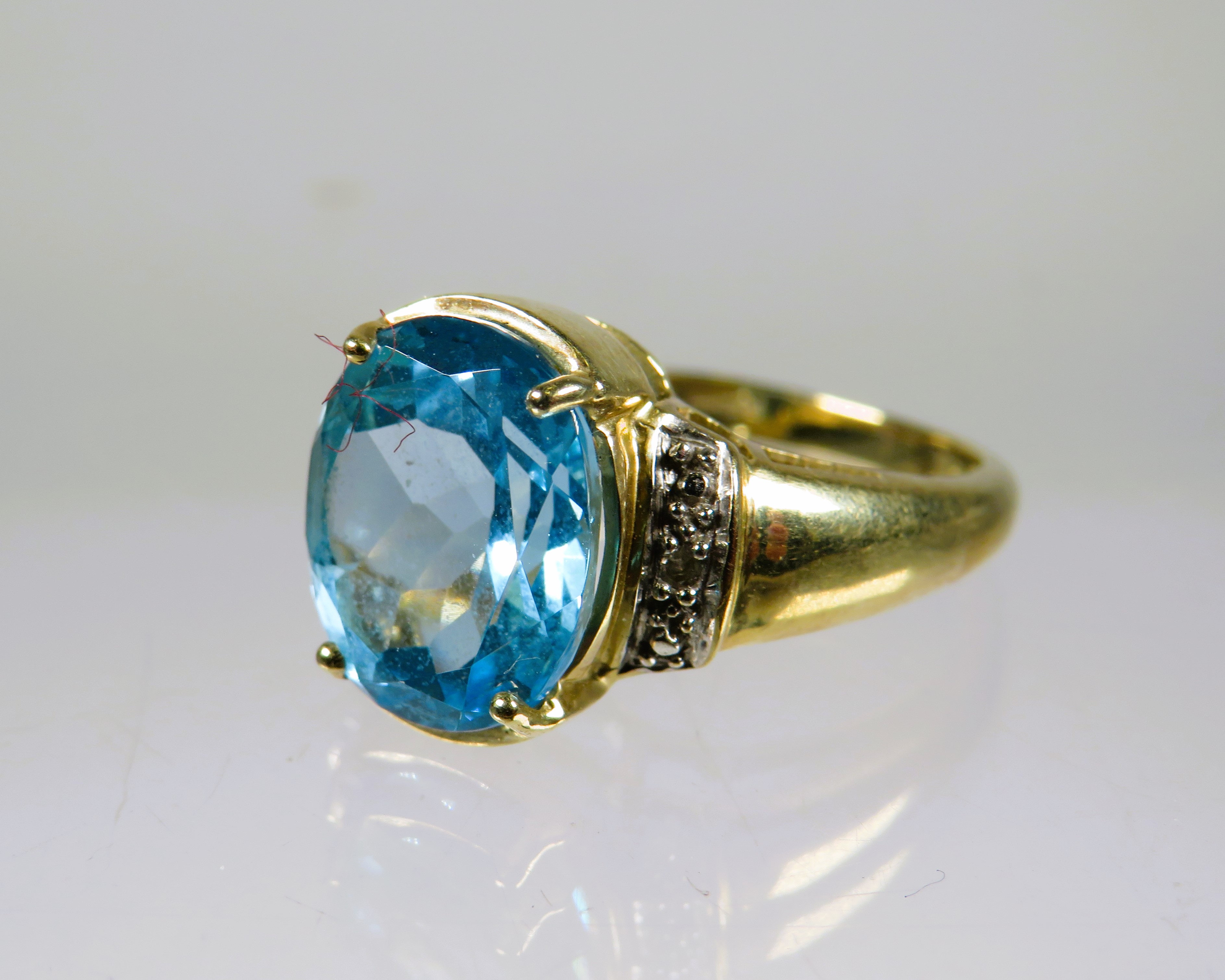 9ct Yellow Gold Ring set with a lovely large Topaz which measures 12 x 8 mm with melee Diamonds to t