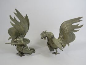 Pair of white metal fighting cockerels, approx 19cm tall.
