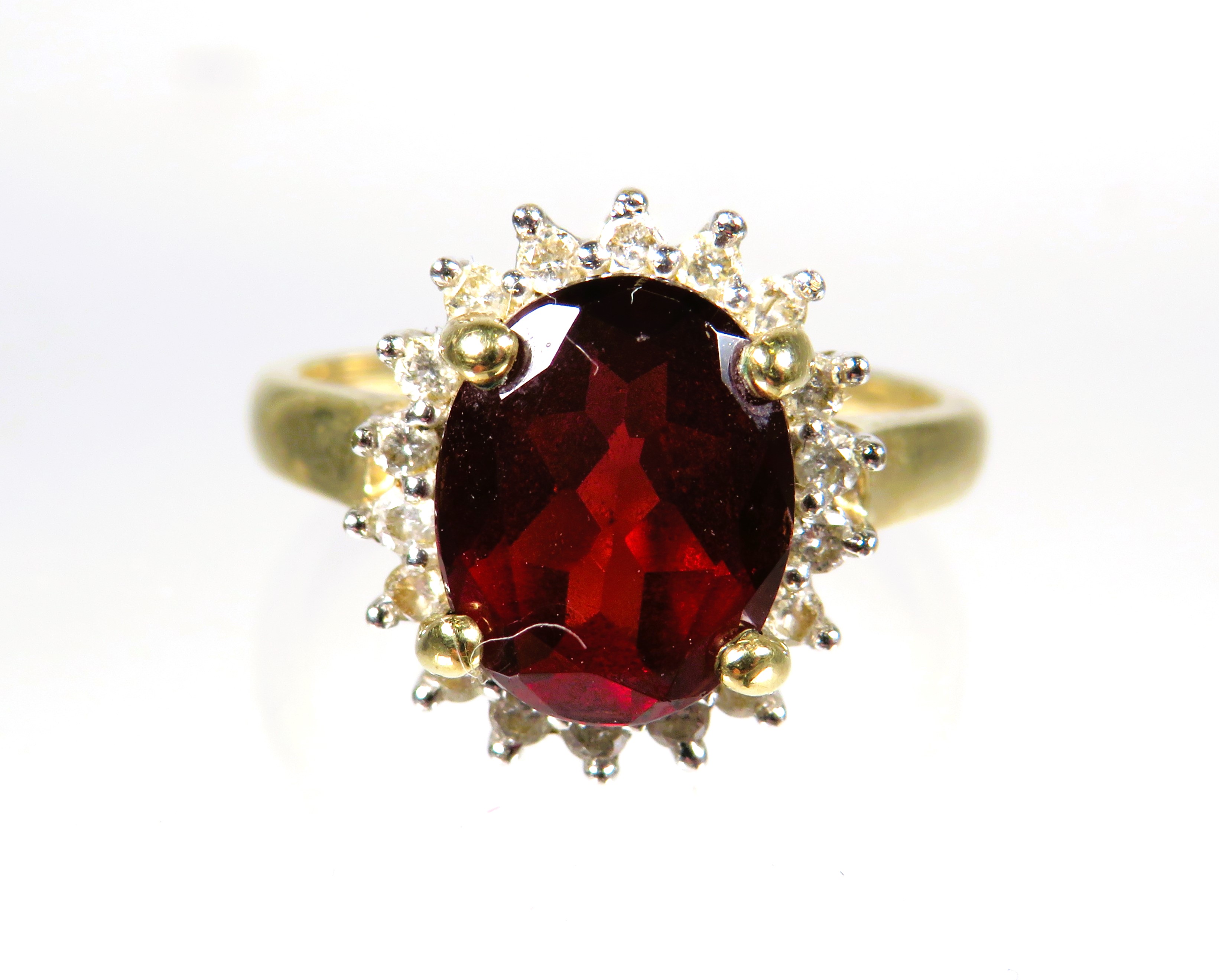 9ct Yellow Gold ring set with a large Oval Garnet which measures approx 10 x 8 mm with Diamond Surro