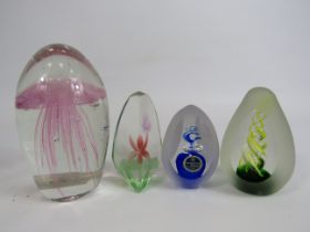 Four art glass paperweights.