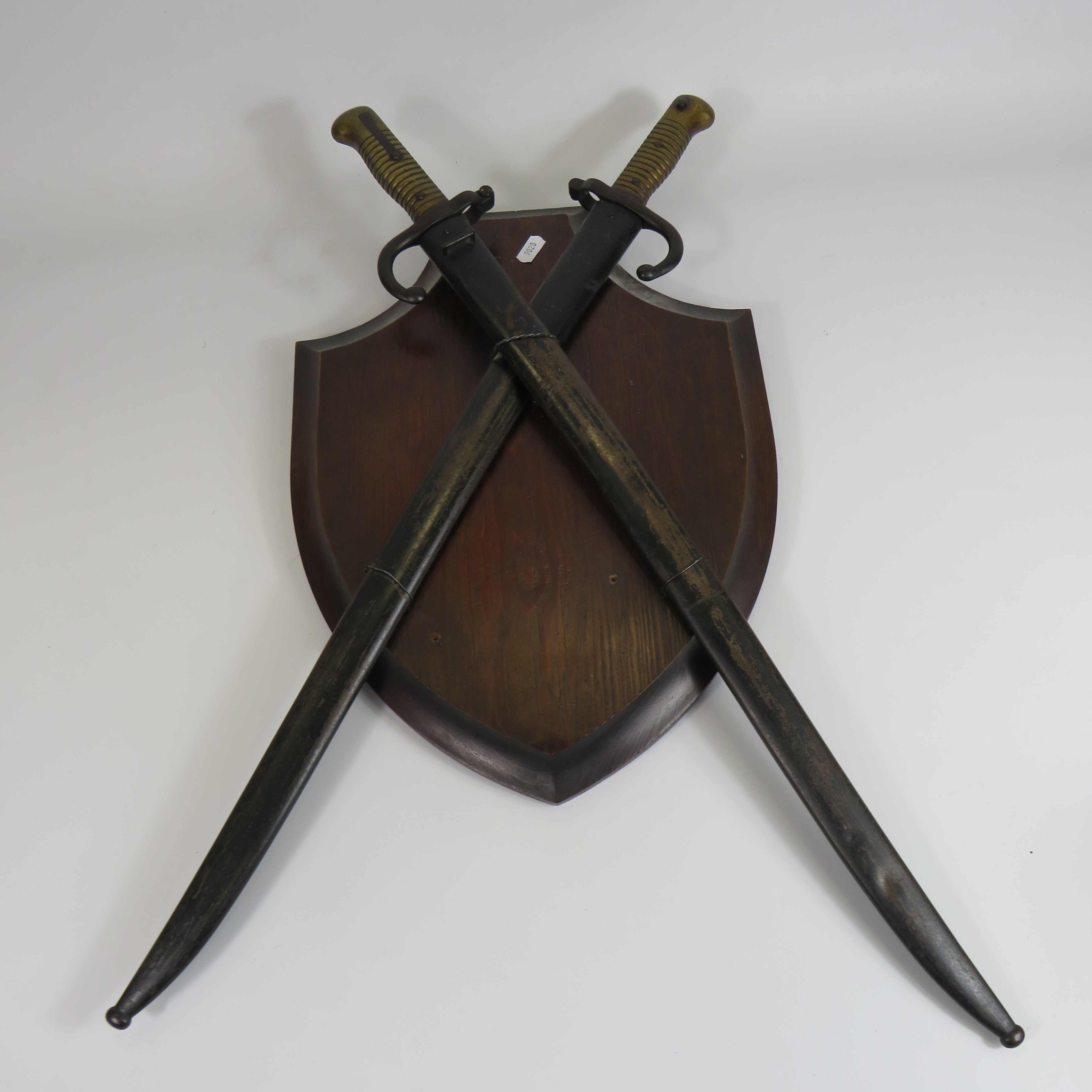 A pair of Chassepot french bayonets mounted on a wooden sheild one bears the date 1868.