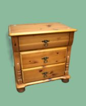 Three drawer pine table on bun feet with applied decorations. H:23 x W:21 x D:15 inches. See photos