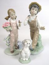 2 Lladro and 1 Nao figurines Boy and girl and a dog, Boy and girl both have boxes.