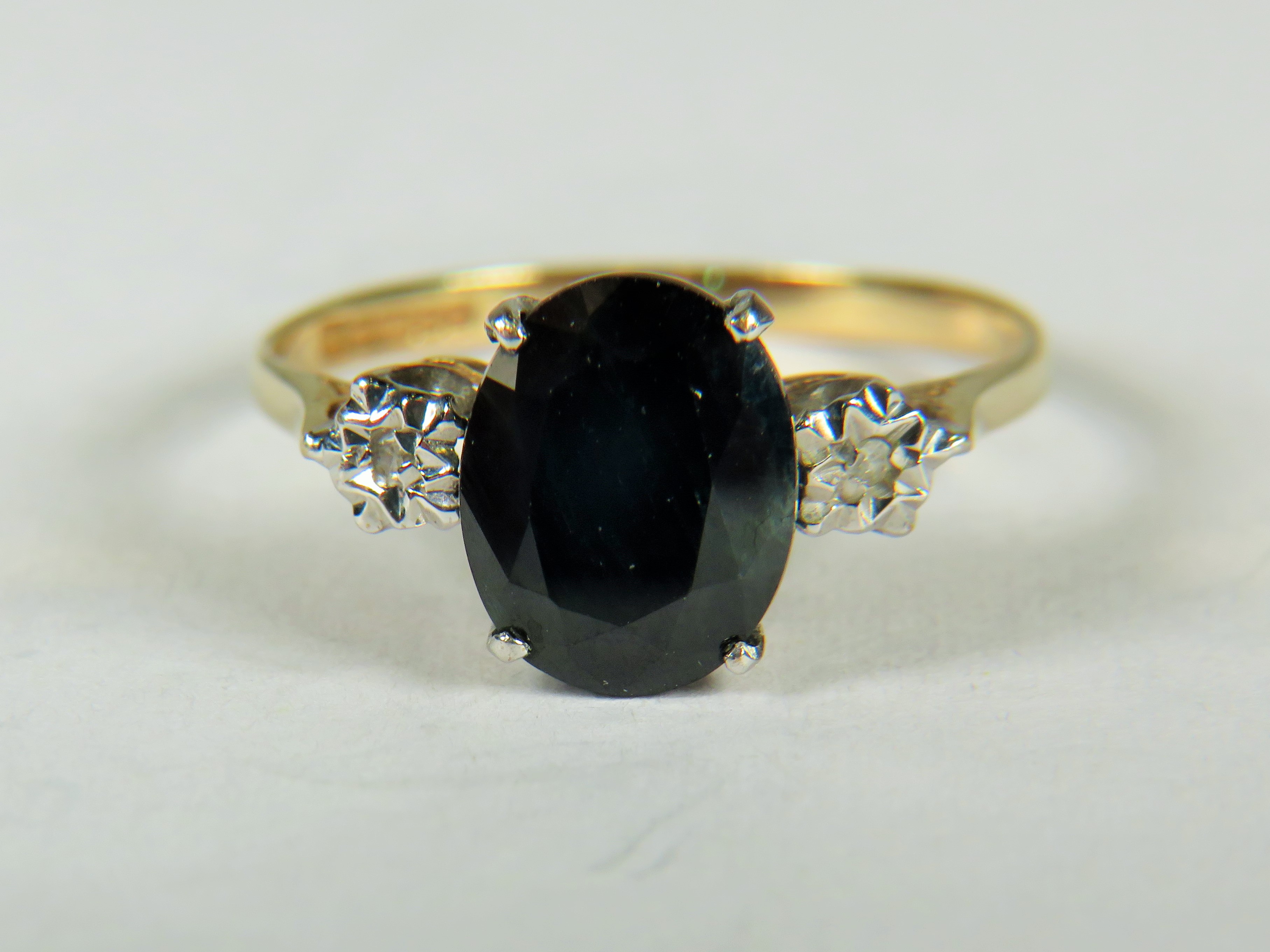 9ct Yellow Gold ring set with a Central oval Sapphire with Diamonds set to shoulders.   Finger size 