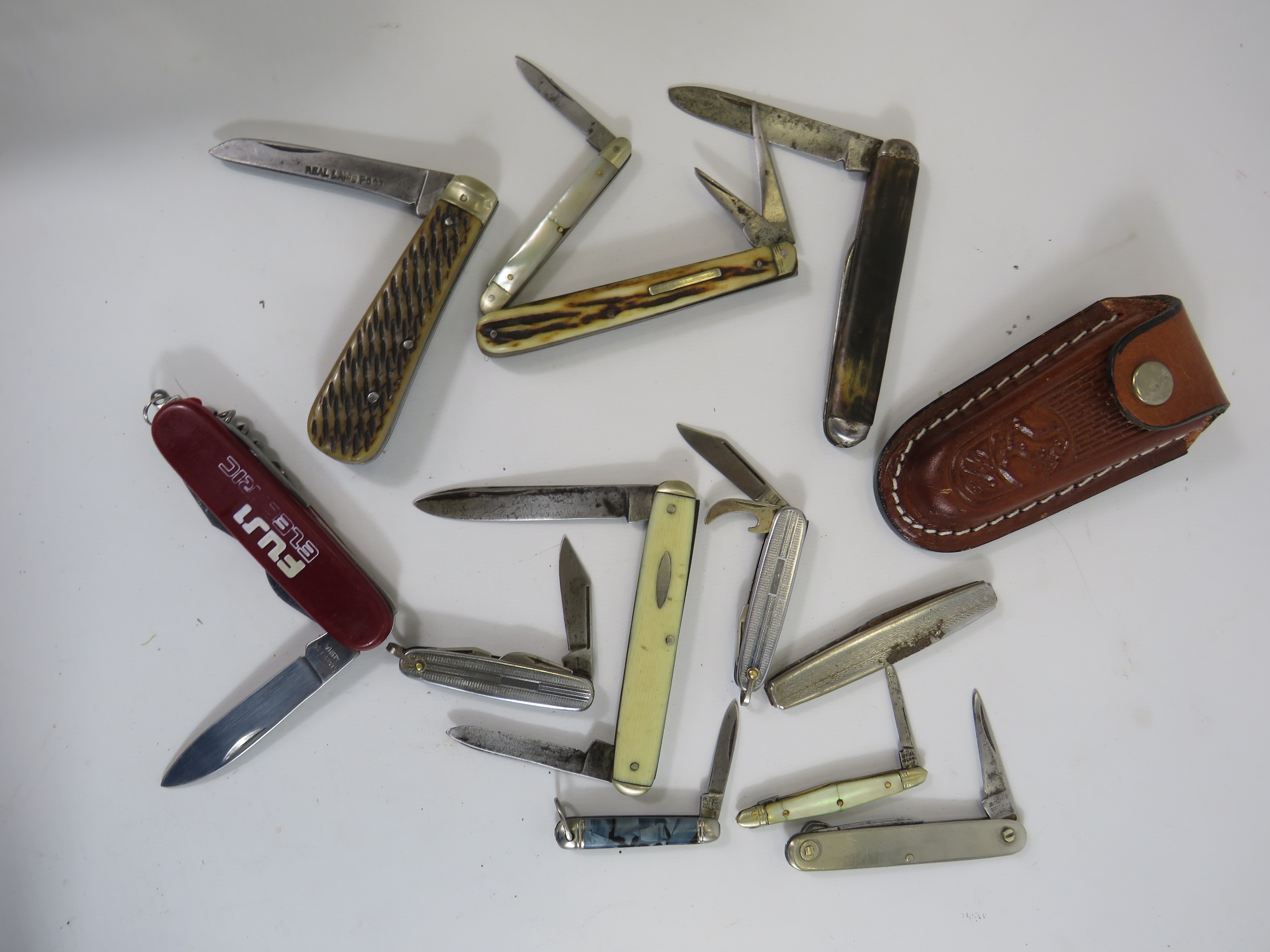 12 Various vintage penknives and a leather knife holster.