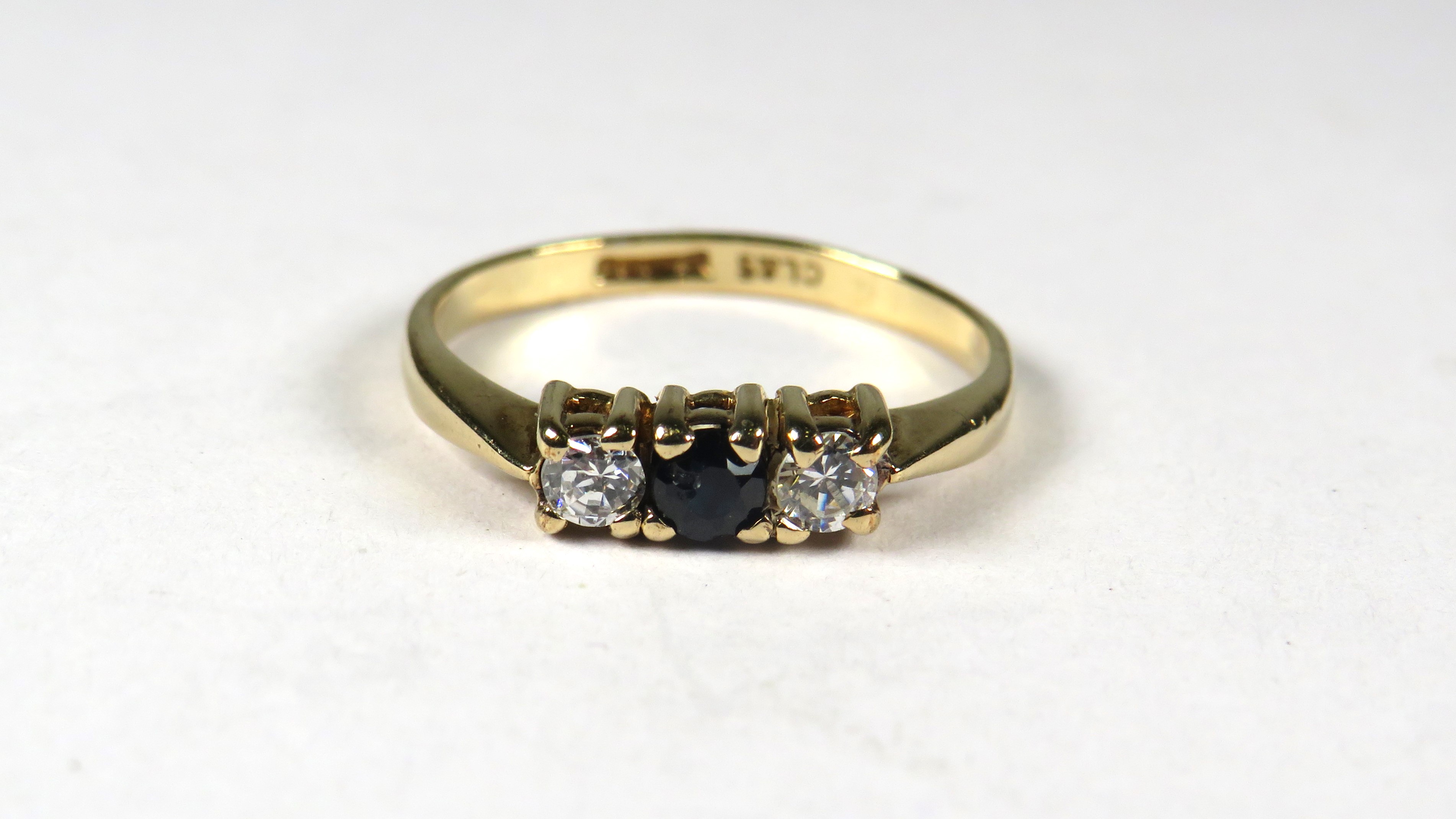 9ct Yellow Gold ring set with a small Central Sapphire Flanked by CZ.  Finger size 'K'    1.3g