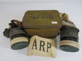 2 Henley gas masks with original tin and a ARP arm band.