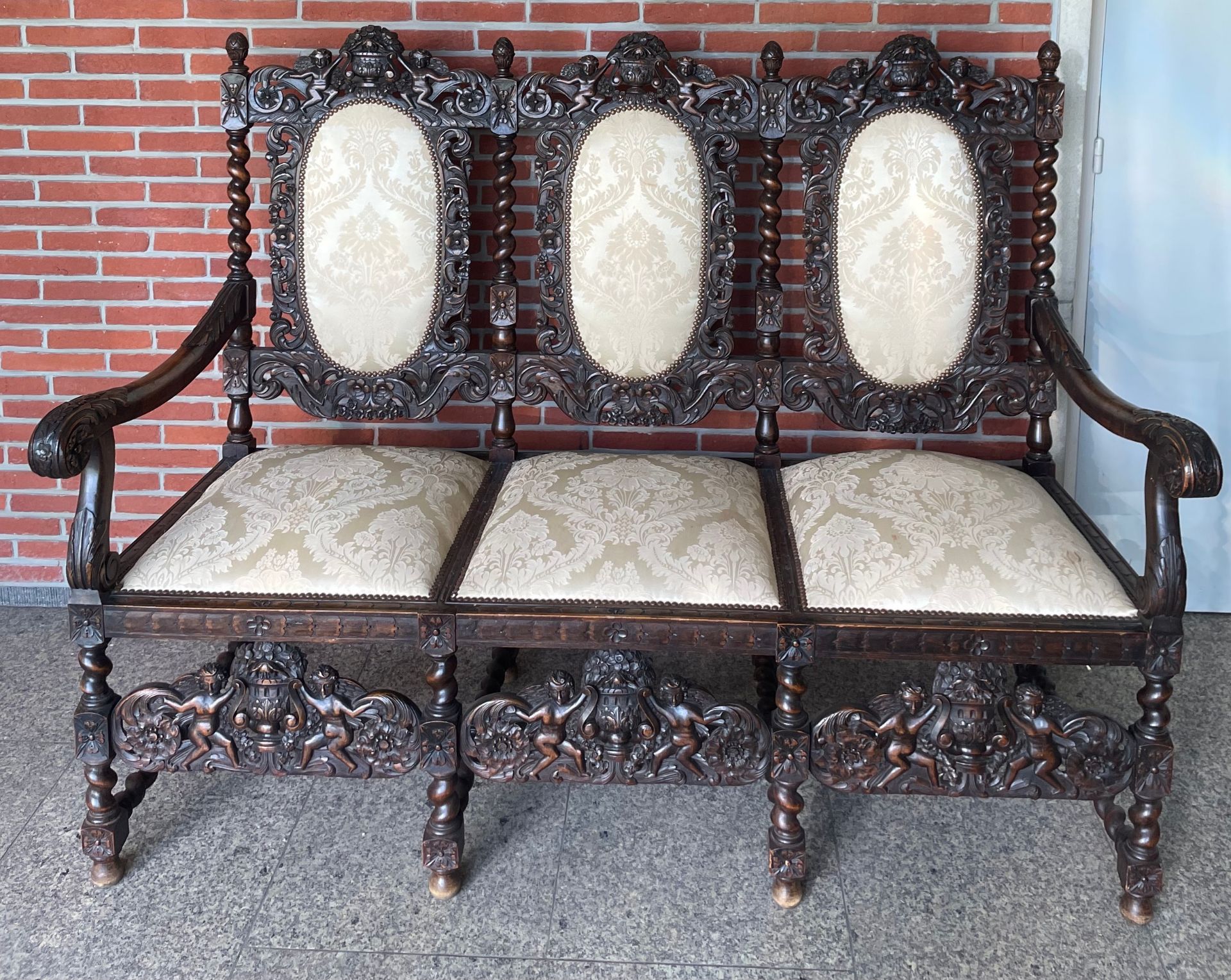 Heavily Carved  settee in late 17th century style. With Cherub Decoration Sofa  The triple-chair