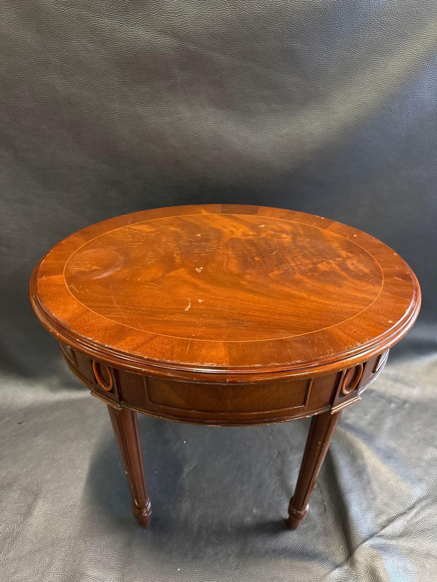 A Mahogany Ovoid Side Table The Freize Carved With Panels And Medallions Raised On Turned Fluted