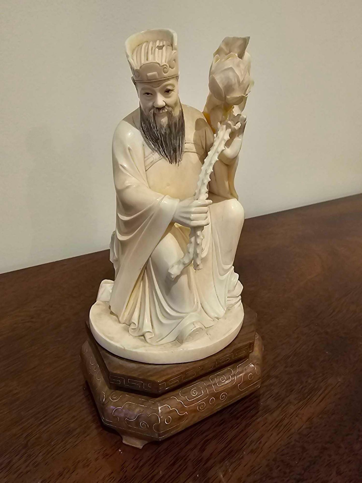 Early 20th C. A Decorative Chinese Ivory Figure Of An Immortal Modelled Seated With A Oversized