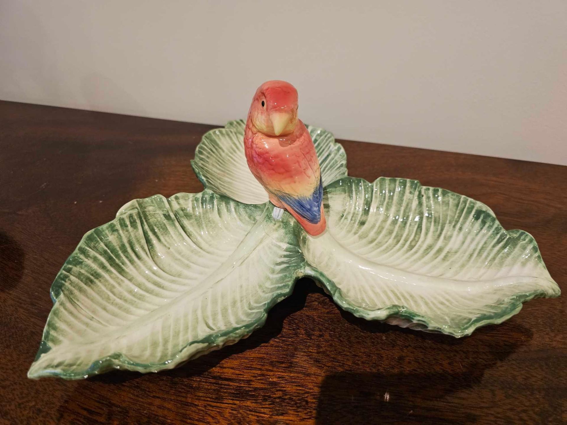 A Fitz Floyd Style Porcelain Dried Fruit Bowl Depicting A Parrot On A Trio Of Shallow Leaf Conjoined