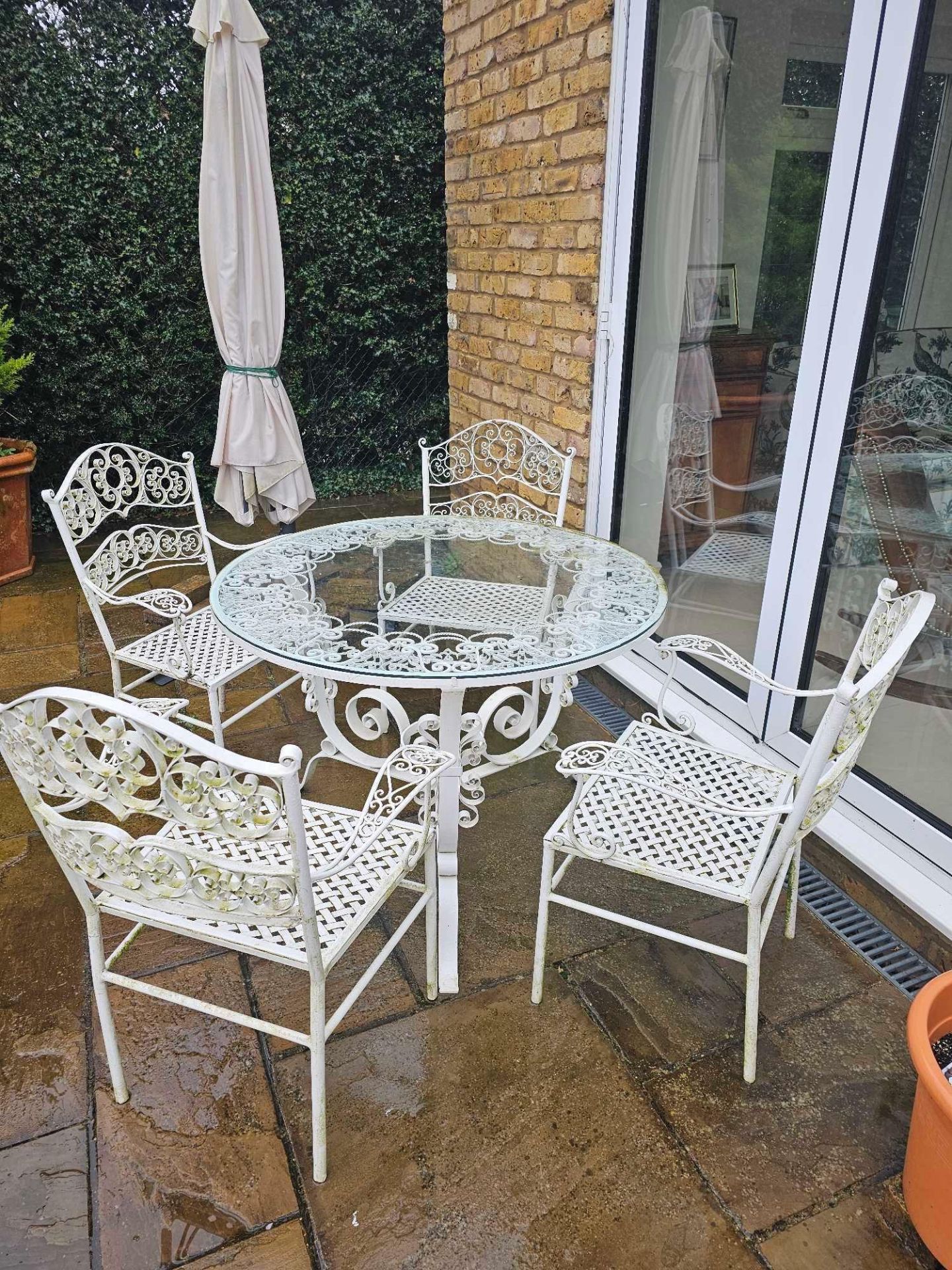 A Wrought Iron Painted White Glass Topped Garden Table Complete With 4 Chairs And A Parasol With