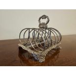 A George IV Style Silver Toast Rack 7 Bar With Rocaille Oval Handle And Border On Similar Bracket