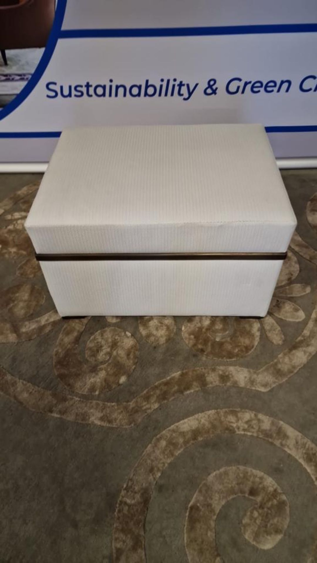 A bespoke ottoman made by George Smith Ltd in a cream patterned fabric with bronze strap details and