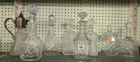 SHELF OF DECANTERS & STOPPERS PLUS A CLARET JUG